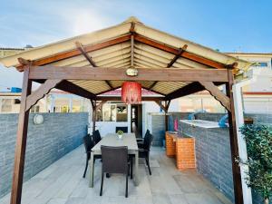 een houten paviljoen met een tafel en stoelen op een patio bij Casa Azul in Torreira