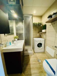 een badkamer met wastafel en wasmachine bij Casa Azul in Torreira