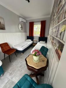 ein Zimmer mit 2 Betten und einem Tisch mit Blumen darauf in der Unterkunft Forteca, pokoje gościnne nad stawem in Dzierżoniów