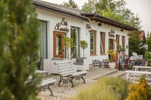 un edificio bianco con panchine di fronte di Forteca, pokoje gościnne nad stawem a Dzierżoniów