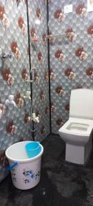a bathroom with a toilet and a bucket at Yogitha farmhouse and Home stay in Hyderabad