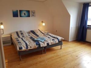 Ce lit se trouve dans une chambre dotée de parquet. dans l'établissement Beach/Marina House, à Nørreby