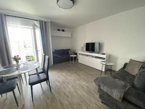 a living room with a couch and a table at Plac Słowiański 10 - Silver in Świnoujście