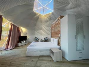 Schlafzimmer mit einem Bett und einer Decke mit einem Fenster in der Unterkunft Mountain View Hotel Complex in Yabulkovets