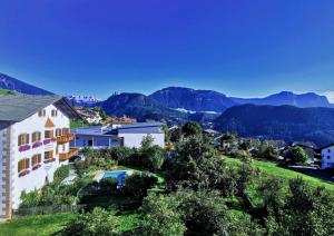 una casa su una collina con le montagne sullo sfondo di Garni Tschutscherhof a Laion