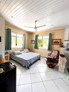 Meri Lodge Huahine « ROOM OF MARTA » في فار: غرفة نوم فيها سرير وكرسي