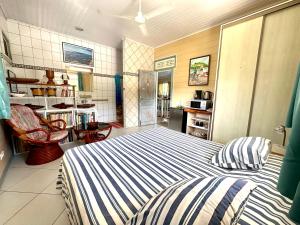 Meri Lodge Huahine « ROOM OF MARTA » في فار: غرفة نوم بسرير ومطبخ