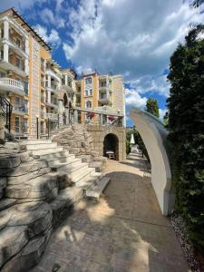 a stone pathway in a city with buildings and a bridge at Sweety SP apartments in Sunny Beach