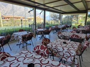 una habitación llena de mesas y sillas con montañas en el fondo en Garnì Casa Rabagno, en Malcesine