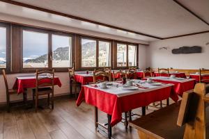 a restaurant with tables and chairs with red table cloth at Hotel la Rotonde in Verbier