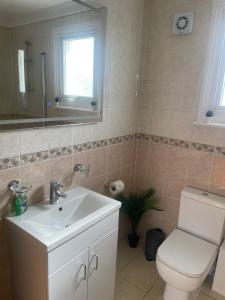 a bathroom with a toilet and a sink and a mirror at The Anglesea - 8 Bedroom with Parking in Southampton