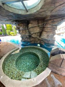 a pool with a stone wall and a swimming pool at Sweety SP apartments in Sunny Beach