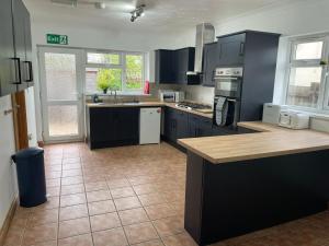 A kitchen or kitchenette at The Anglesea - 8 Bedroom with Parking