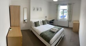 a bedroom with a bed with a desk and a window at The Anglesea - 8 Bedroom with Parking in Southampton