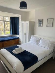 a bedroom with a bed with a towel on it at The Anglesea - 8 Bedroom with Parking in Southampton