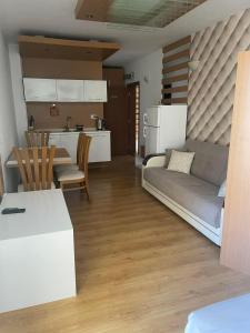a kitchen and a living room with a couch and a table at Sweety SP apartments in Sunny Beach