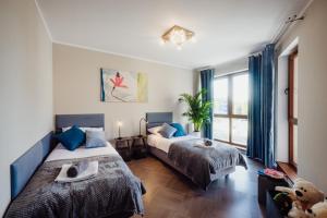 ein Schlafzimmer mit zwei Betten und einem großen Fenster in der Unterkunft 1 Maja 76 in Jelenia Góra