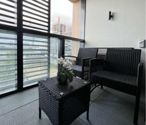 a room with chairs and a table with flowers on it at Myka Home New Apartment in Box Hill YS4A in Box Hill