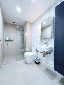 a bathroom with a toilet and a sink and a shower at Myka Home New Apartment in Box Hill YS4A in Box Hill