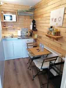 una cucina con pareti in legno, tavolo e sedie di Au Coin Fleuri a Malmedy
