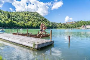 Due bambini che saltano da un molo in un lago di Grand Hotel Astoria a Lavarone