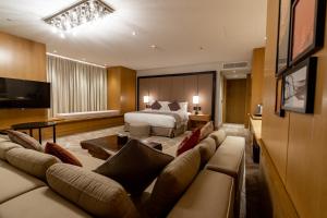une chambre d'hôtel avec un lit et un canapé dans l'établissement جناح جونيور بخدمات فندقية الملك فهد, à Riyad