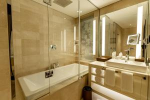 a bathroom with a tub and a sink and a shower at جناح جونيور بخدمات فندقية الملك فهد in Riyadh