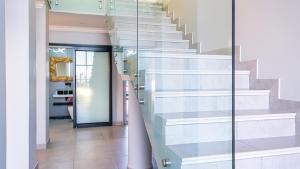 una escalera en una casa con barandilla de cristal en Bella Vista Villa, en Wilderness