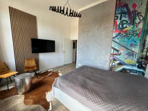 格爾利茨的住宿－DESIGN Apartment I - 35qm Grenze Altstadt Park，卧室配有一张床,墙上挂有绘画作品