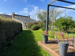 zwei Topfpflanzen sitzen auf einer Terrasse in der Unterkunft 207 - Jolie maison mitoyenne entre terre et mer en campagne de Plurien in Plurien