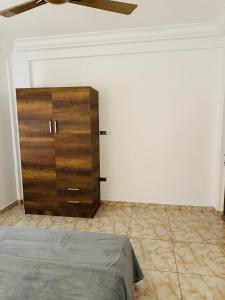 um quarto com uma cómoda de madeira num quarto em Best Apartment em Adentan