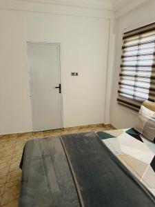 um quarto com uma cama e uma porta num quarto em Best Apartment em Adentan