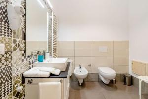 een witte badkamer met een wastafel en een toilet bij B & B Il Giardino sul Mare in Briatico