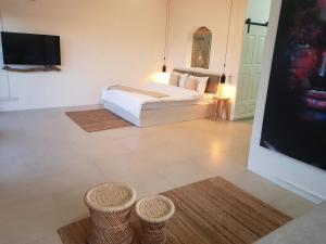 una camera con un letto e due sgabelli di Villas Rocher - Deluxe Suite 2A a Grand Baie
