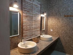 La salle de bains est pourvue de 2 lavabos et de 2 miroirs. dans l'établissement Villas Rocher - Deluxe Suite 2A, à Grand Baie