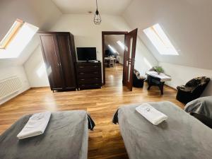 a attic room with two beds and a television at Dom Supełek in Duszniki Zdrój