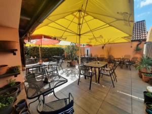a patio with tables and chairs and yellow umbrellas at Penzion Avena in Stříbro