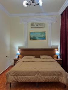 سرير أو أسرّة في غرفة في السفراء للأجنحة الفندقية