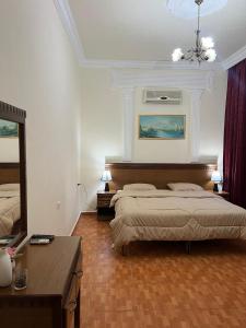 1 dormitorio con 2 camas y espejo en Sufara Hotel Suites, en Amán