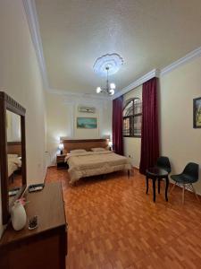 a bedroom with a bed and a table and chairs at Sufara Hotel Suites in Amman