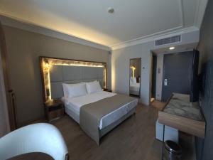 a hotel room with a large bed and a television at The Yalı Konak Hotel İzmir in İzmir