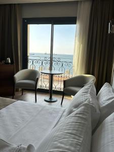 a bedroom with a bed and a view of the ocean at The Yalı Konak Hotel İzmir in Izmir