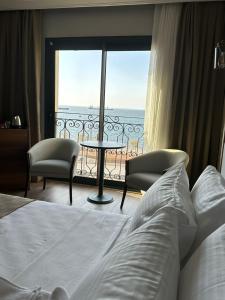 The Yalı Konak Hotel İzmir في إزمير: غرفة نوم مع سرير وإطلالة على المحيط