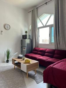 sala de estar con sofá rojo y mesa en Lusy's studio Family Park, en Abu Dabi