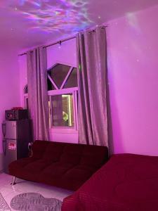 a purple room with a couch in front of a window at Lusy's studio Family Park in Abu Dhabi