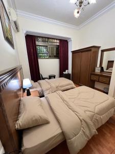 1 dormitorio con 2 camas y ventana en Sufara Hotel Suites, en Amán