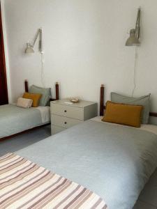 sypialnia z 2 łóżkami i komodą w obiekcie Casa Pérola, Old Town Apartment w Albufeirze