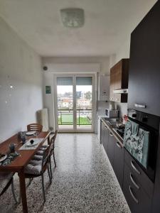 a kitchen with a table and a dining room with a window at Appartamento Clizia in Pescara