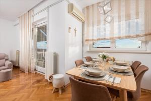 een eetkamer met een houten tafel en stoelen bij Apartman Adriatic in Rijeka