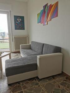 salon z szarą kanapą w pokoju w obiekcie Appartamento Clizia w mieście Pescara